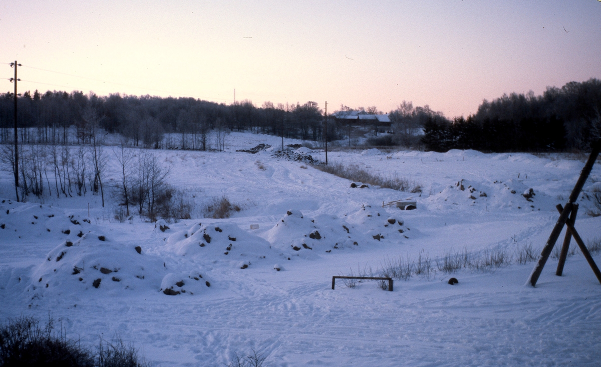 Högengårdarna ses i bakgrunden och till höger Kyrkskogen, vintern cirka 1975. Närmast till höger skymtas Vommedals lekplats.