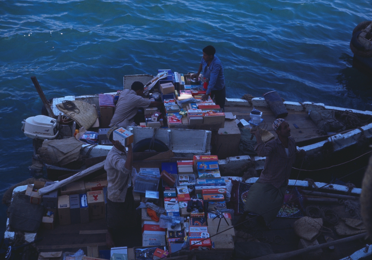 Bilden visar handlare med två småbåtar fullastad med varor som försöker sälja till Älvsnabbens besättning.