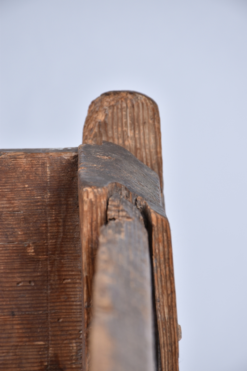 Rotekista av trä. Rektangulär med på bredsidorna inristade drakslingor, ändarna är prydda med prickade och släta rutor.