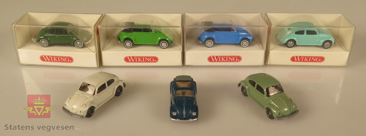 Samling av flere modellbiler. 3 biler er grønne, 3 biler er blå og 1 bil er hvit. Alle er laget av plast og har en skala på 1:87