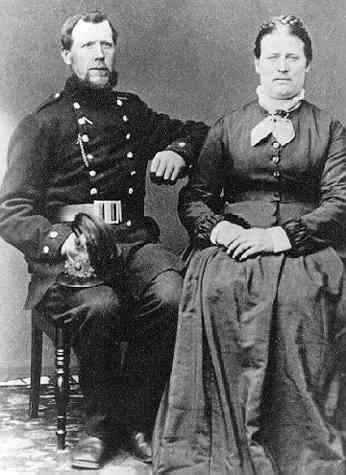 Gruppbild med paret Johan Alfred Grenlund och Johanna Larsdotter. Mannen bär militär uniform.
