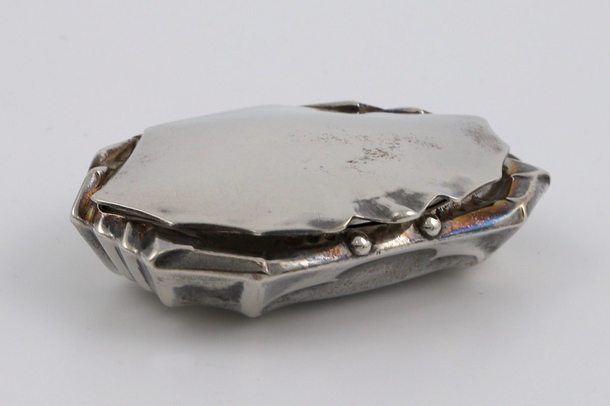 Dåse med lokk i drevet sølv, hvis form alluderer til en krabbe. Uten stempel.