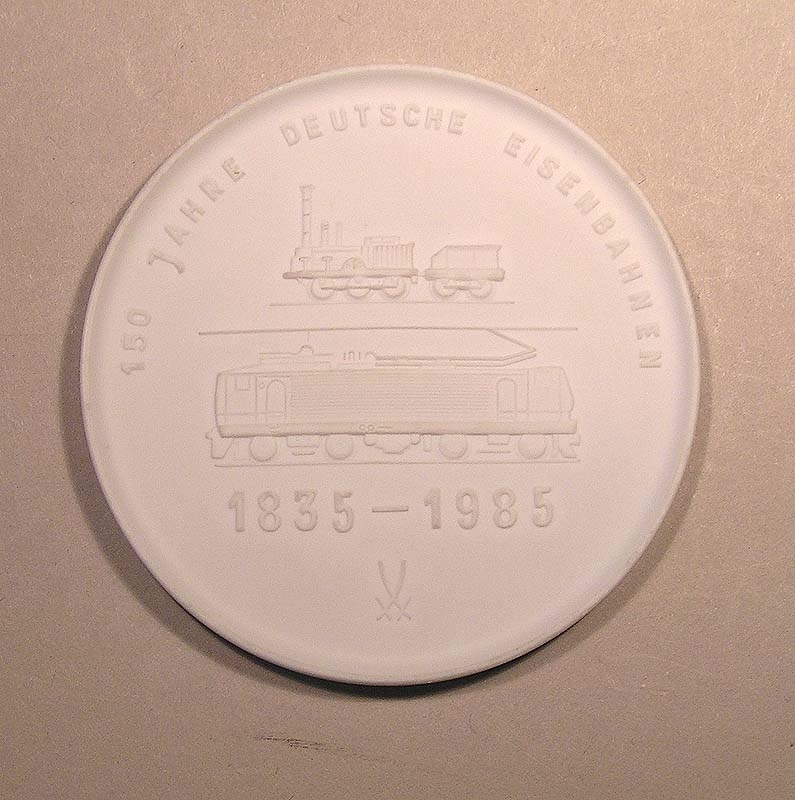 Minnesmedalj eller plakett av vitt porslin från Tyska Järnvägen 150 År
1835-1985.
Text på ena sidan: "40 Jahre Eisenbahn in Volkes Hand". På andra sidan: "150 Jahre Deutsche Eisenbahnen".