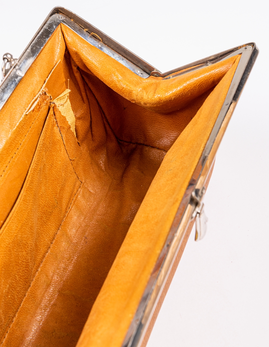 Handväska av gult kalvskinn, bygel av nickel, handtag av flätat skinn.