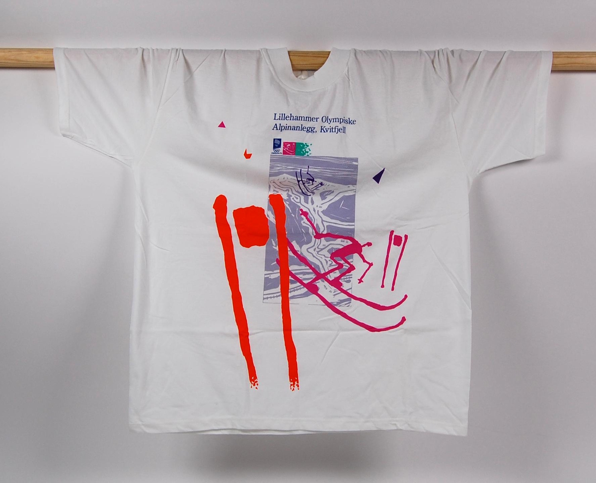Hvit t-skjorte i størrelse XL. Foran på t-skjorten er det en liten logo for de olympiske vinterleker på Lillehammer i 1994 og et stort flerfarget motiv av en alpinbakke med piktogrammer av to alpinister.