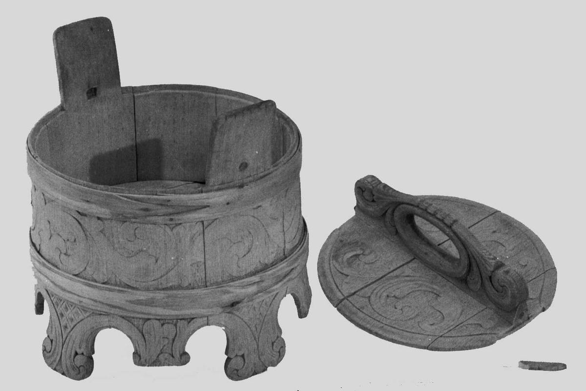 Ambaren er lagget av ni staver, hvorav fire er forlenget til bein og to til ører. Bein og ører skrår utover. To flate gjorder. Beina er dekorert med skåren akantusdekor. Rundt ambaren går en bladrik akantusranke i lavt relieff. Ørene har stripeskurd.
Lokket  er laget av tre biter satt sammen av håndtaket. Akantusskurd både på lokket og håndtaket. Håndtaket festet med låsepinne med langstrakt bladform.