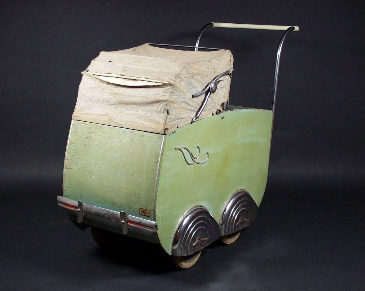 Grønn barnevogn med tilhørende dyne og madrass. Barnevogna har kalesje og skjerm i plastmateriale. Kalesjen er av stoff og har blitt noe slitt. 