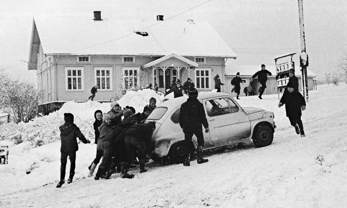Hammer gamle skole. Barn skyver bil på vinterføre.