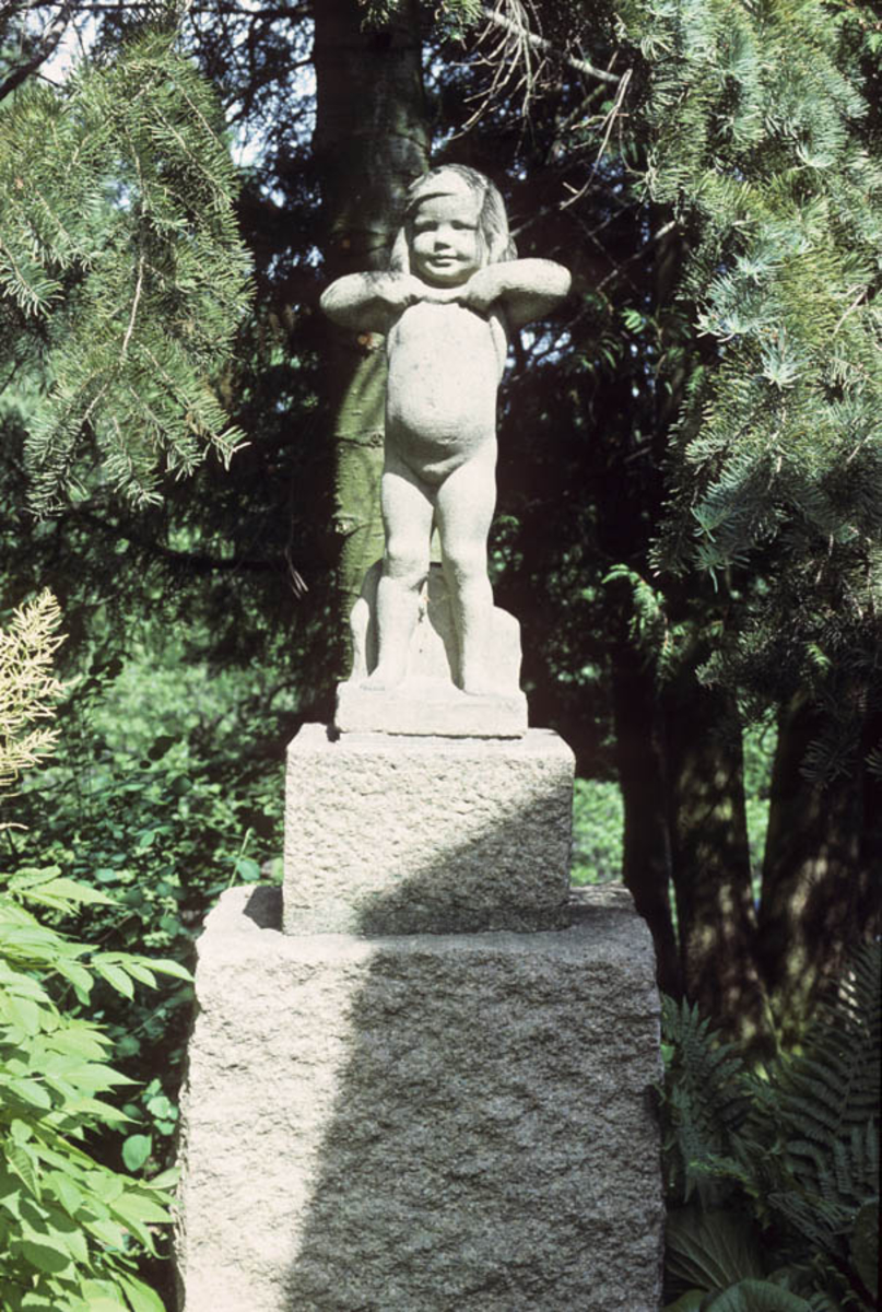 Statue av en liten pike, laget  i steinmateriale.