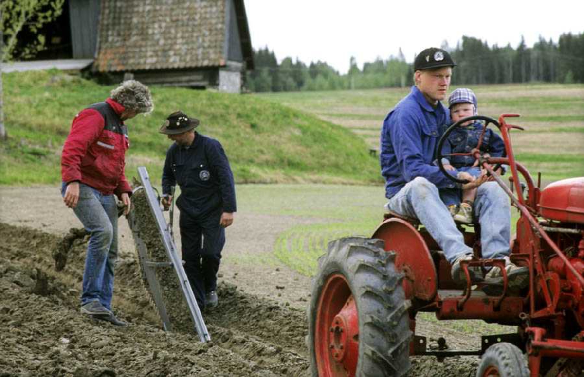 Dokumentasjon av drenering i forbindelse med åpning av ny utstilling: "Jordbrukets utvikling på Romerike" på Gamle Hvam. Bruk av dreneringsredskaper. Demonstrering av drenering. Mann (Christoffer Hønsen) og gutt på traktor, to menn går bak (mann med hatt er trolig Øyvind Kværner)