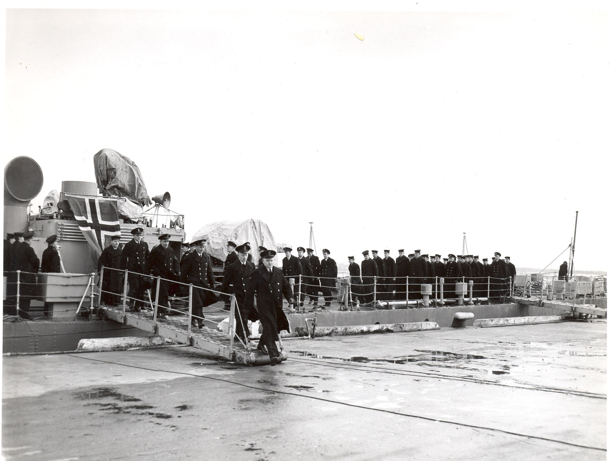 Overtakelsen av River-kl.fregatt KNM "Draug", ex. HMCS Pentang 25. januar 1956. Det kanadiske mannskapet går i land etter at kommandoen er strøket på HMCS Pentang.