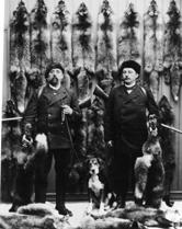 To revejegere med gevær, hund og reveskinn. Mathias Pedersen