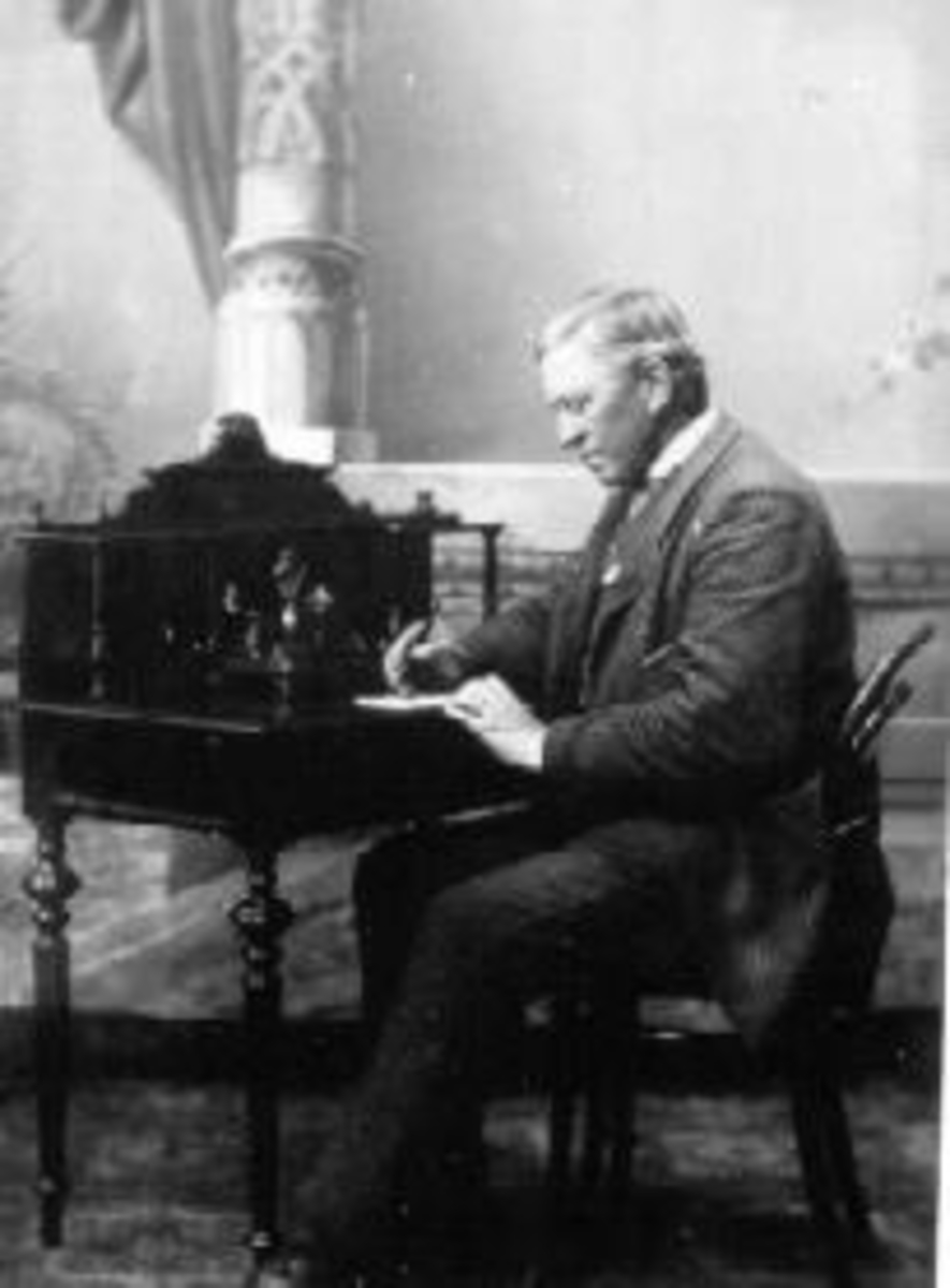 Even Arnt Gjestvang (1829-1927) fotografert i studio ved skrivepult. Revisor. Kise Østre, Nes, Hedmark.