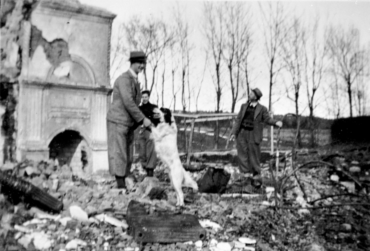 Inspeksjon av branntomta på Hovinsholm, Helgøya etter storbrannen den 20.12.1937. Gartner Kjølås til høyre og Georg Ørbekk med hunden som varslet brannen.