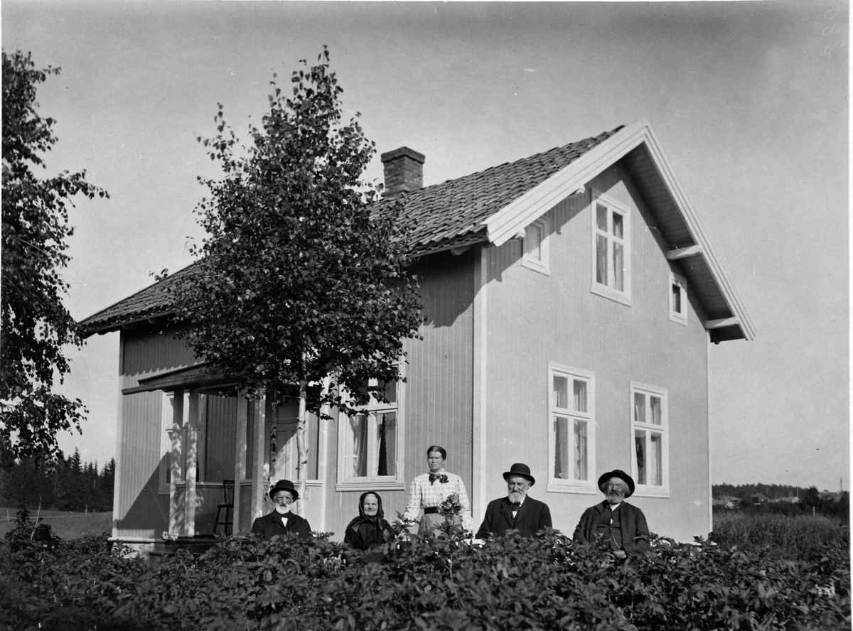 Gruppe voksne foran hus, Snarud/Arnkvern, Furnes, Ringsaker.
