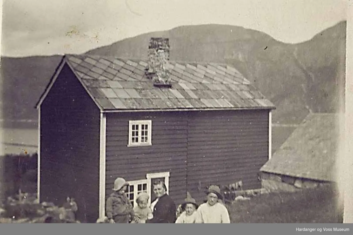 Gruppe, kvinne, born, bygninger2, fjell, fjord. Gamlahuset i Erdal sett frå baksida