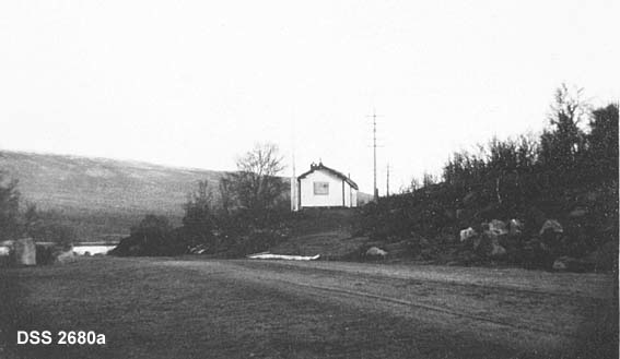 Slakter Andersens hytte i Dovre statsallmenning.  To kopier, den ene sett fra vegen, den andre fra ei li med sjø og fjell i bakgrunnen. 