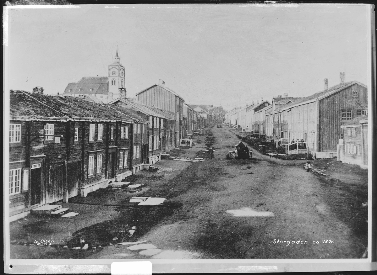 Bergmannsgata på Røros ca 1870. Vannpost midt i bildet og bebyggelse på begge sider av gata fra sørenden og oppover.