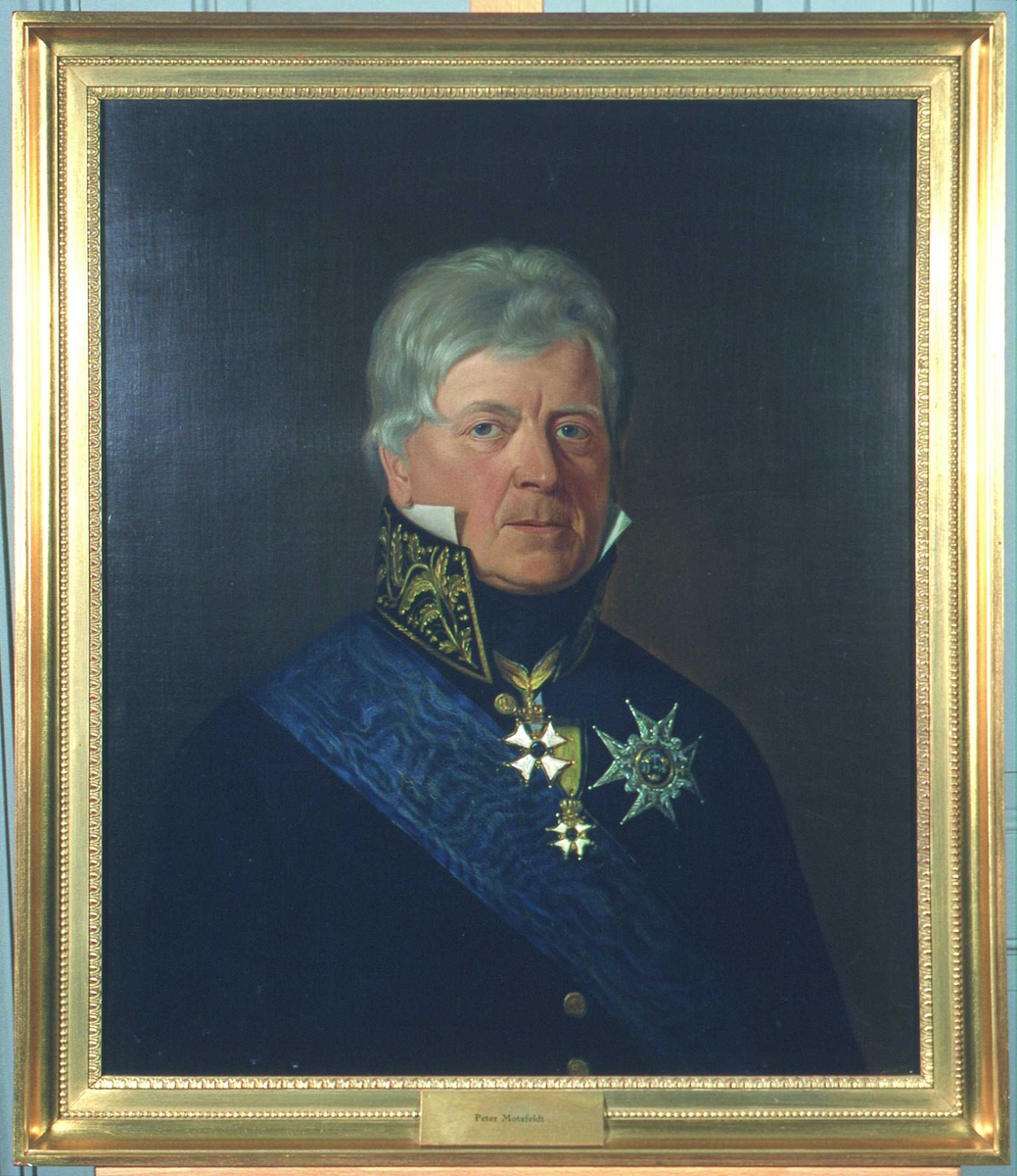 Portrett av Peter Motzfeldt.
Grått, kort hår.  Statsrådsuniform (etter 1815), høy krave m/gull, blått ordensbånd, 3 ordener.