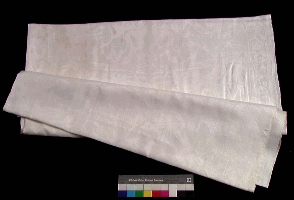 Hvit damask duk i lin, vevd i to delar sydd sammen midtpå.
