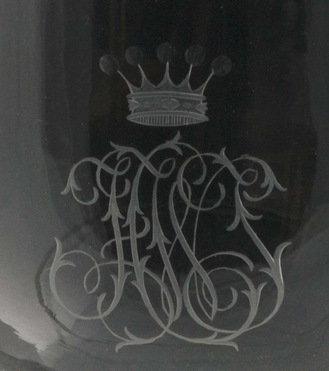 Pokal; glass, kompakt fot og stett, cupa bolleformet med hvit kant øverst. Gravert monogram med krone.