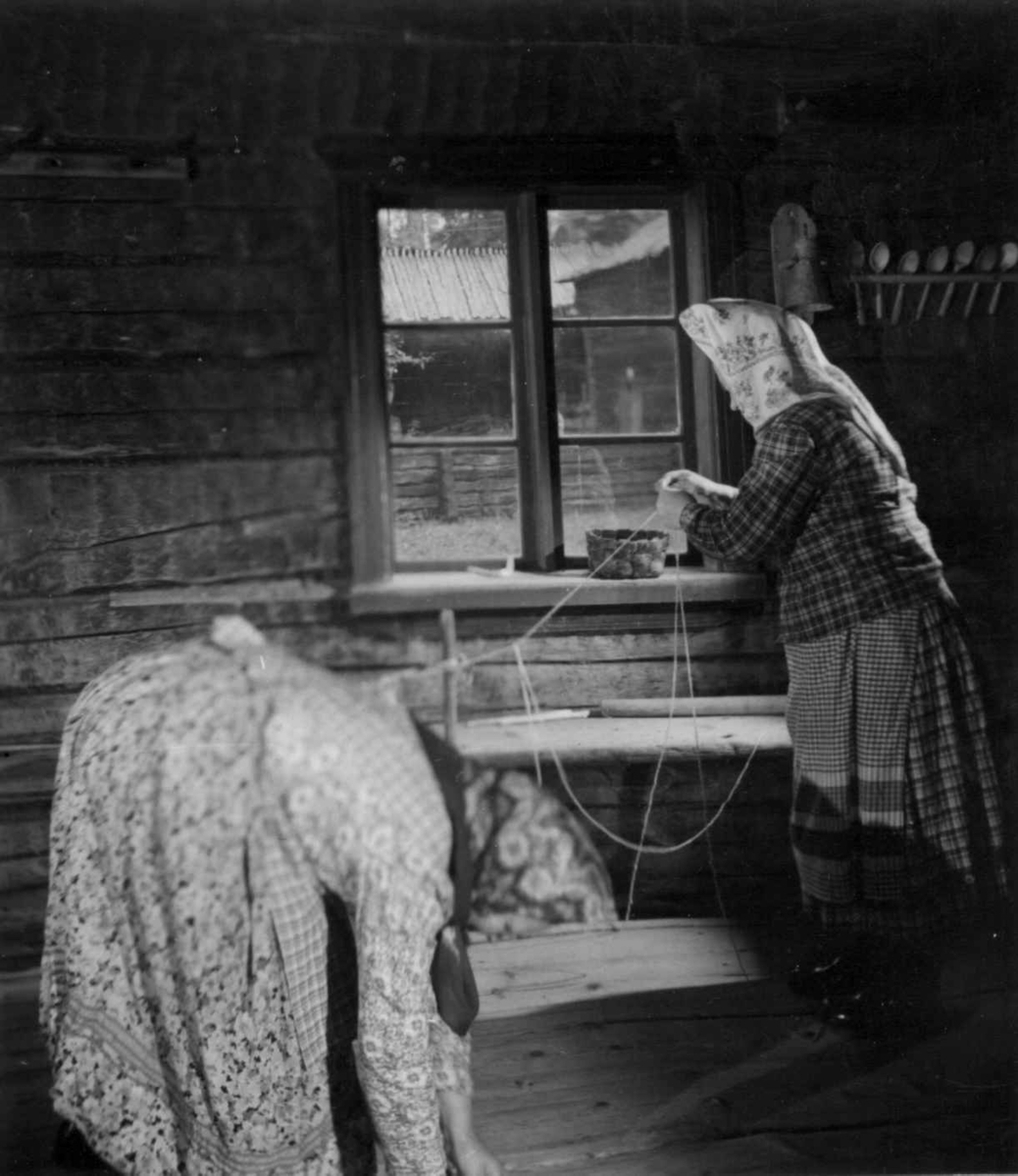 Greneveving (8). Skoltesamene Darja Jefreimov og Naska Moshnikov  lager renning til greneteppet, Darja fletter jaretråden. Seurasaari 1955.