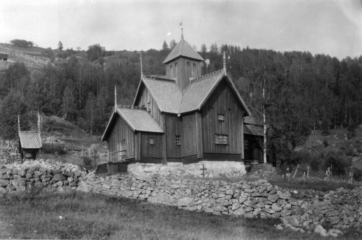 Uvdal kirke, Nore og Uvdal, Buskerud. 1930. Kirkegård. Gravkors. I bakgrunnen landskap med skog  og åkrer.