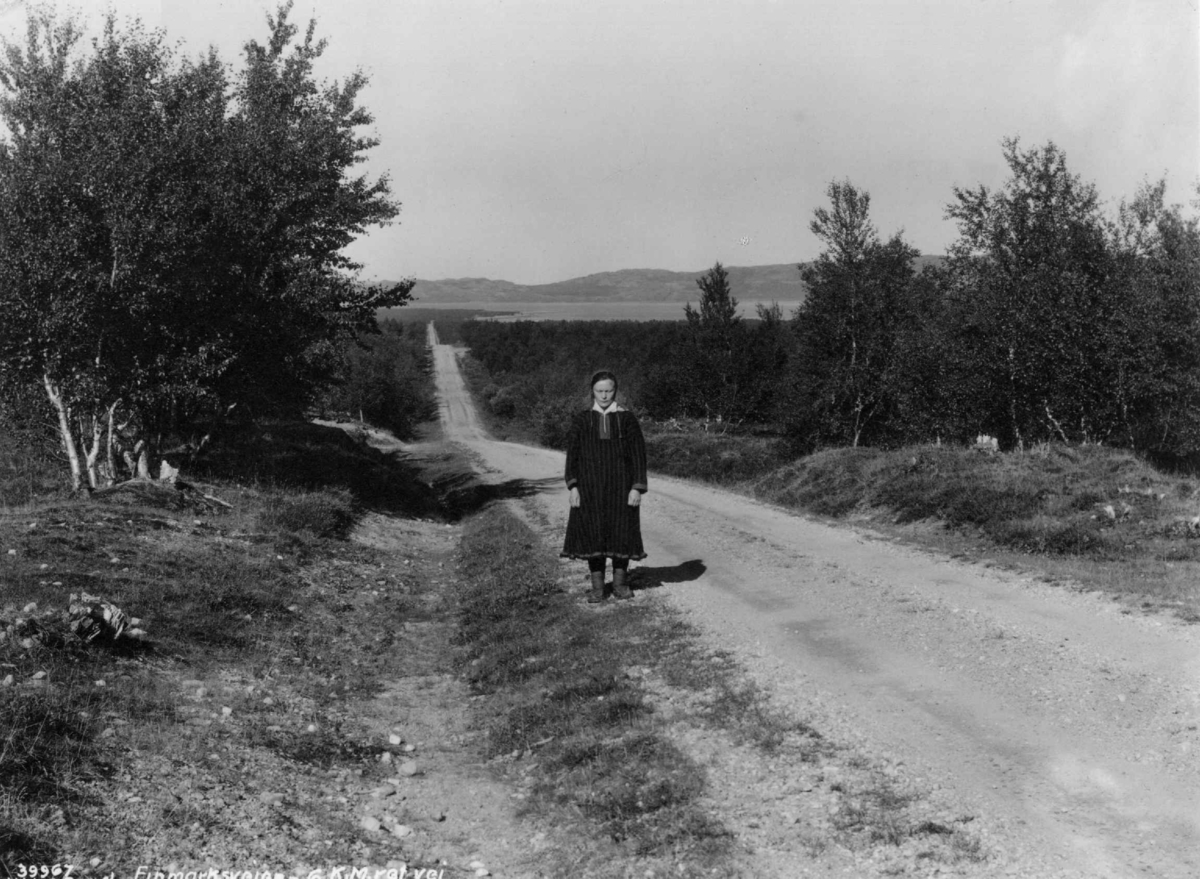En kvinne på Finnmarksveien ned mot Porsangerfjorden.