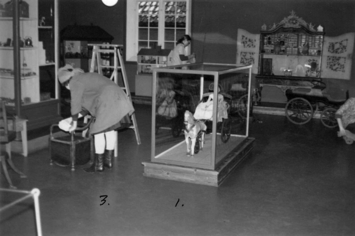 Aase Berger i forgrunnen og Eva Lunde gjør rent i leketøysutstillingen i desember 1974.