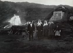 Familien Johansen i samisk drakt foran gamme ved Adamsfjordf