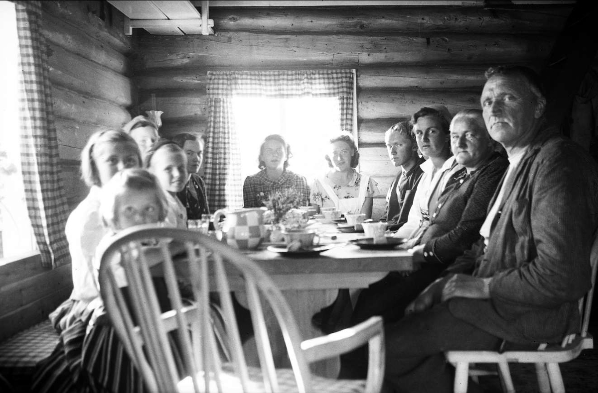 Familien Arentz samlet rundt spisebordet sammen med venner på Ligardshaugen 1940.
