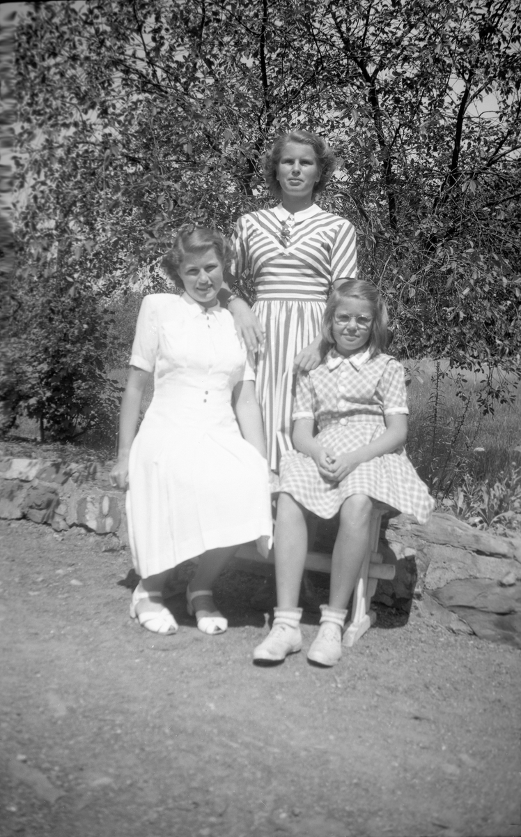 Guri Arentz står bak sine søstre Kari og Siri som sitter på en krakk. Fotografert 14. juni 1947.