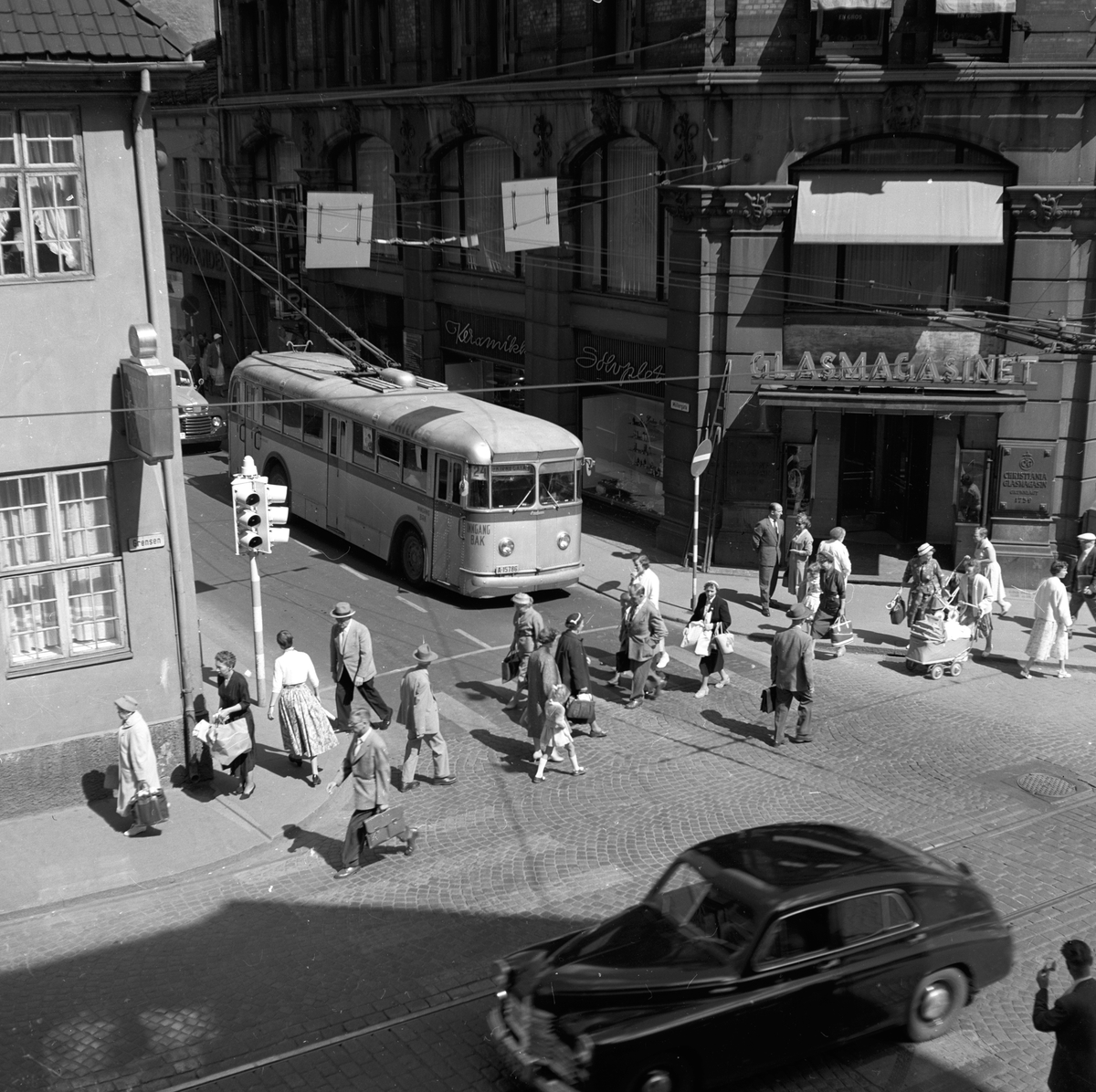 Fotgjenger går over fotgjengerfelt i krysset Møllergata og Stortorvet ved Glasmagasinet, Oslo. Fotografert 1. juni 1963.