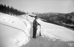 Kari Arentz måker vei med kost til nedsnødde Ligardshaugen i