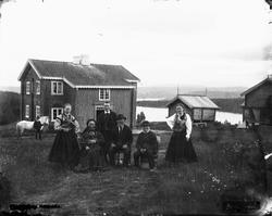 Gruppeportrett med folkedrakt på gårdstun iTelemark antakeli