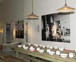 Utstillingsplakater med bilder fra Bastøy skolehjem. Lamper,