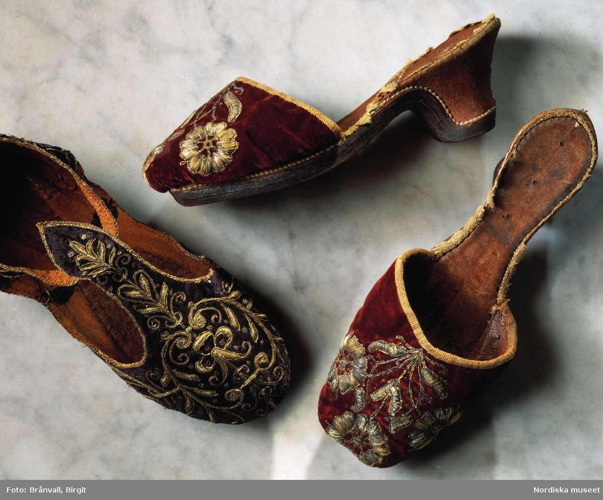 Praktfulla damtofflor av röd sammet, broderade med guldtråd och fodrade med brunt skinn. Första hälften av 1600-talet. Ur Nordiska museets samlingar.