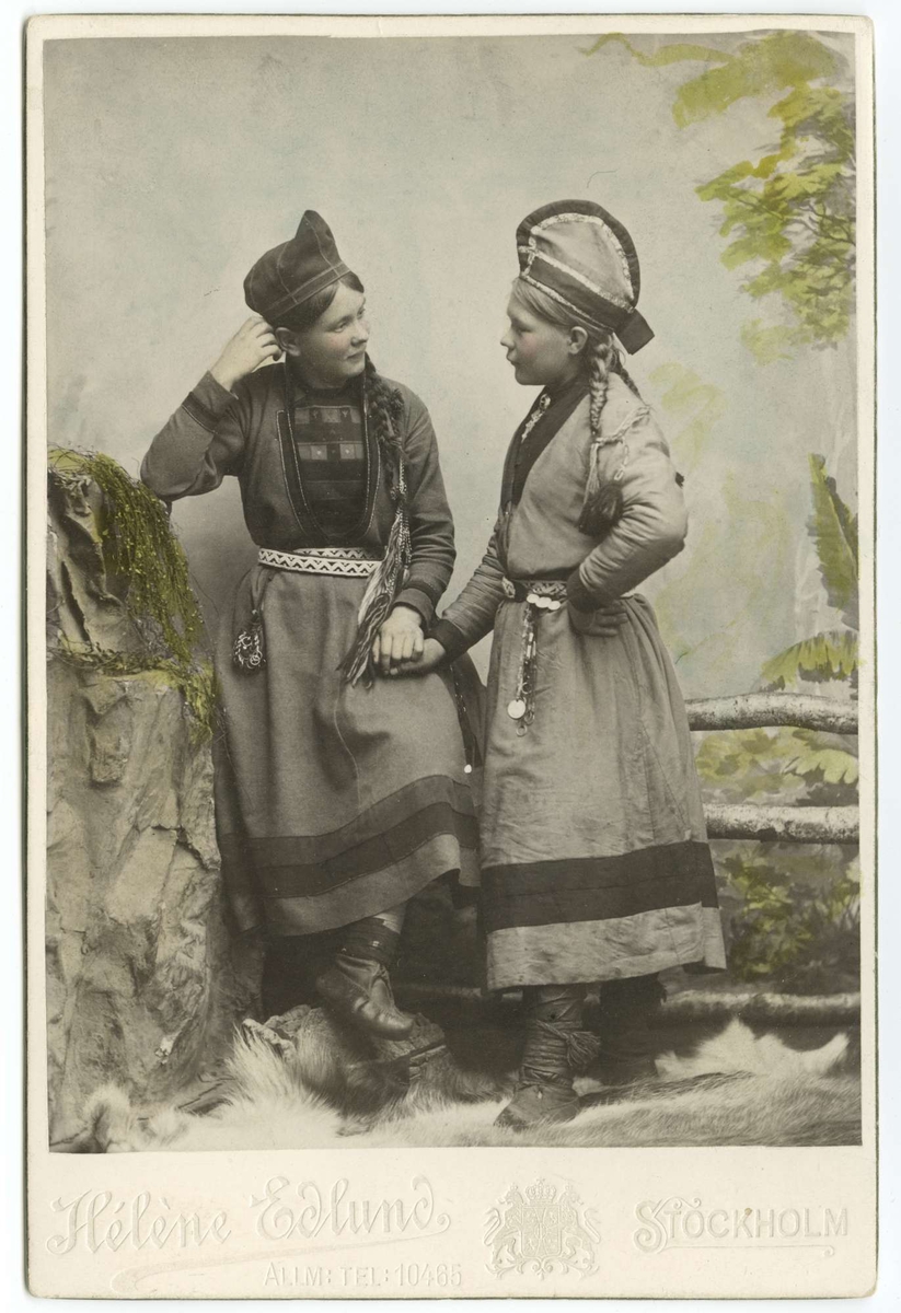 Ateljéporträtt. Två unga samekvinnor klädda i kolt. Kvinnan t.v. är enligt uppgift Inga Åren.