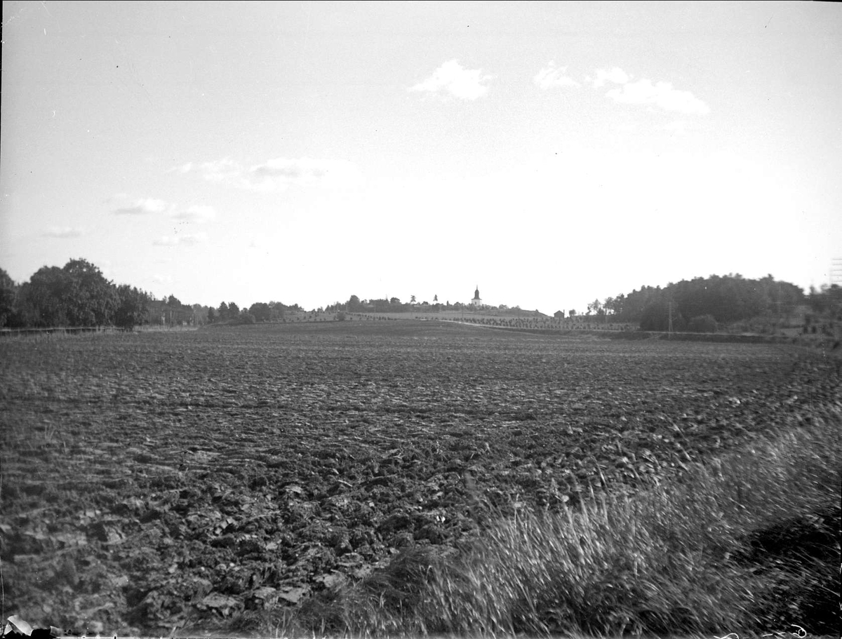 Landskapsvy med plöjd åker i förgrunden i Rotebro, Sollentuna socken, Uppland september 1923