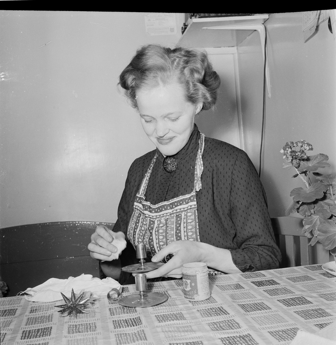 Karin, sonhustru till lantbrukare Dina Eriksson, 1955 års mottagare av Insulanderska priset, putsar ljusstakar