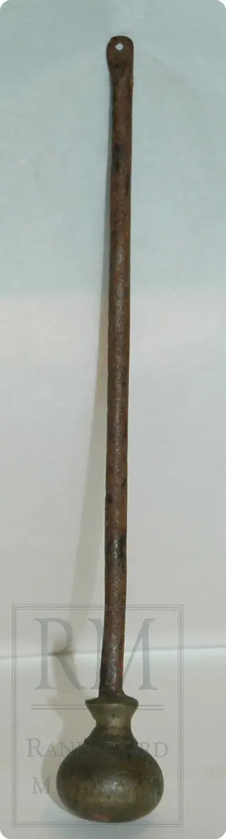 Bismervekt av jern. En avlang sylinderformet stav - med et lodd i den ene enden. Loddet er av messing.  Staven skulle hatt en krok av jern i ene enden.