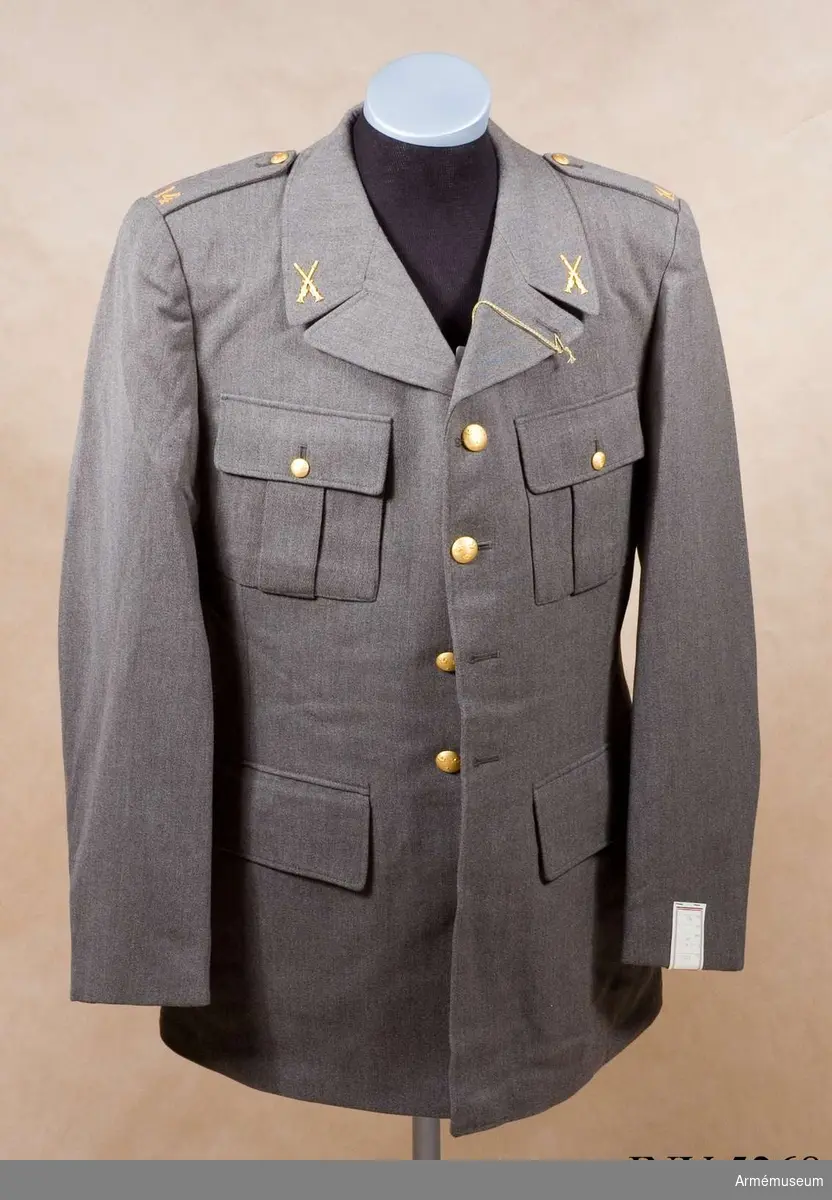 Av samma snitt som uniform m/1939. Daglig dräkt av gråbrungrönt tyg. Bärs till mörkt gråbrungröna byxor. Tjänstetecken mattförgyllda. Stl: 104 II.