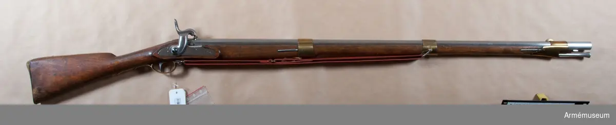Grupp E II b.
Reparationsmodell.
Vapnet är ursprungligen ett i Huskvarna år 1825 tillverkat flintlåsgevär m/1815, se AM 1932:4209, vilket senare försetts med sikte enligt 1838 års förordning och 1861 ändrats till slaglås enligt den 1849 fastställda förändringsmodellen (se AM 1932:4404). Nominalkaliber 18,55 mm. Verklig kaliber 18,3 mm. 

Pipan är blank. Baktill på pipans översida står H,IM, dubbelt C, krönt CB,CM och AL. På H platten framför det tärnade fänghålet är inslaget HMO och på den V platten 530 samt S. På undersidan P, 2, M, 71, stämpel med tre bokstäver av vilka den första är otydlig, men de bägge andra äro EW, dessutom årtalen 1825 och 1861. Låset överensstämmer helt med det å AM 1932:4404.

På bleckets utsida finnes H och 530, på insidan HMO, en otydlig stämpel 1861. Stocken är av brunbetsad björk och av 1815 års modell. Bakom varbygelns bakspets finnes ett tre bokstäver bestående stockmakaremärke. På stockens H sida är inslaget 530, 71, 1825 och 1861.

Beslagen äro av 1815 års modell. På sidbleckets och näsbandets insida finnes en stämpel med ett E, men på nedre bandets en med IV. På bakplåtens spets står 206.

Laddstocken är av 1815 års modell samt omärkt.