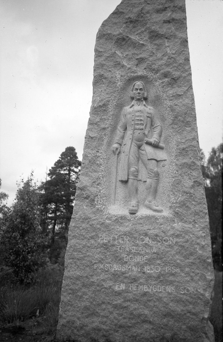 En rest sten med uthuggen mansfigur med texten: Petter Jonsson, Träslända, Bonde, Riksdagsman 1830-1858. En hembygdens son.