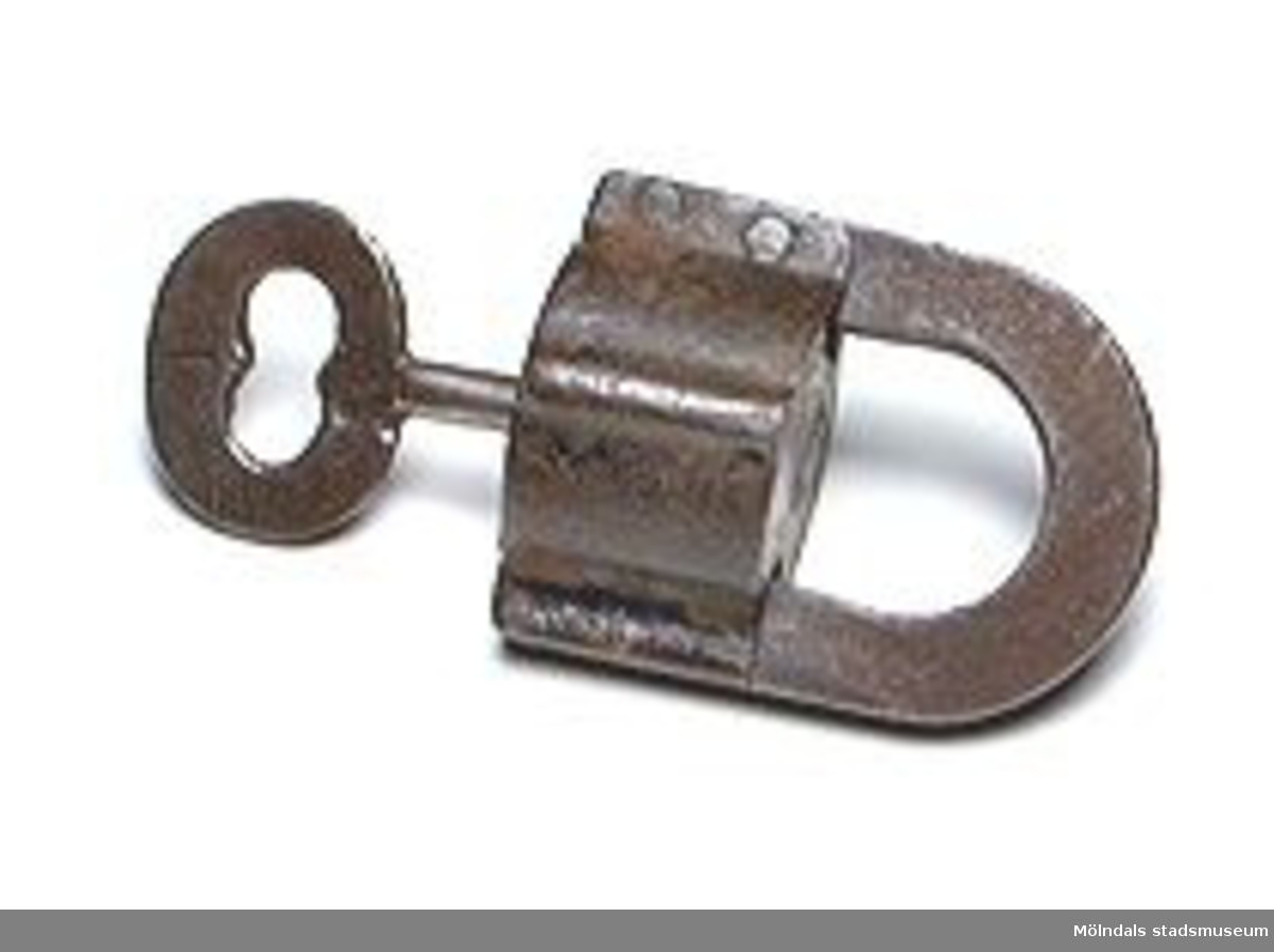 Hänglås av gammal typ, med nyckel. Runt lås. Både låsbygeln och nyckeln är märkta "1".