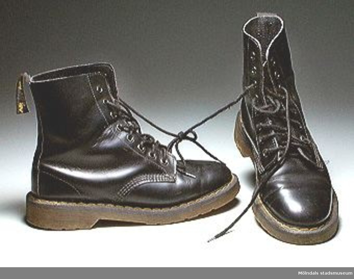 Svarta Dr Martens-kängor. Märkta: Air soles, cushion. Storlek 5. 
Till utställningen "Krinoliner och kortkort" på Mölndals Museum 5 feb. 1995 - 26 nov. 1995.