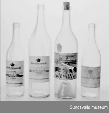 SuM 4970:1-4 fyra brännvinsflaskor i ofärgat glas med etikett. SuM 4970:1-2 har båda etikett med texten 'Bordsbrännvin ORIGINALTAPPNING, VARUMÄRKE, Aktiebolaget Vin- och Spritcentralen'. SuM 4970:1 är 26,5 cm hög och SuM 4970:2 mäter 33 cm. SuM 4970:3 är försedd med kork och mäter 33 cm. Den har en etikett med texten 'Fabrikens Aftappning, REYMERSHOLMS GAMLA SPRITFÖRÄDLINGS AKTIEBOLAG, VARUMÄRKE, ÖDÅKRA TAFFEL AQVAVIT'. SuM 4970:4 har texten 'Originaltappning Absolut rent Brännvin, Aktiebolaget Vin- och Spritcentralen'. Flaskan mäter 26,5 cm.