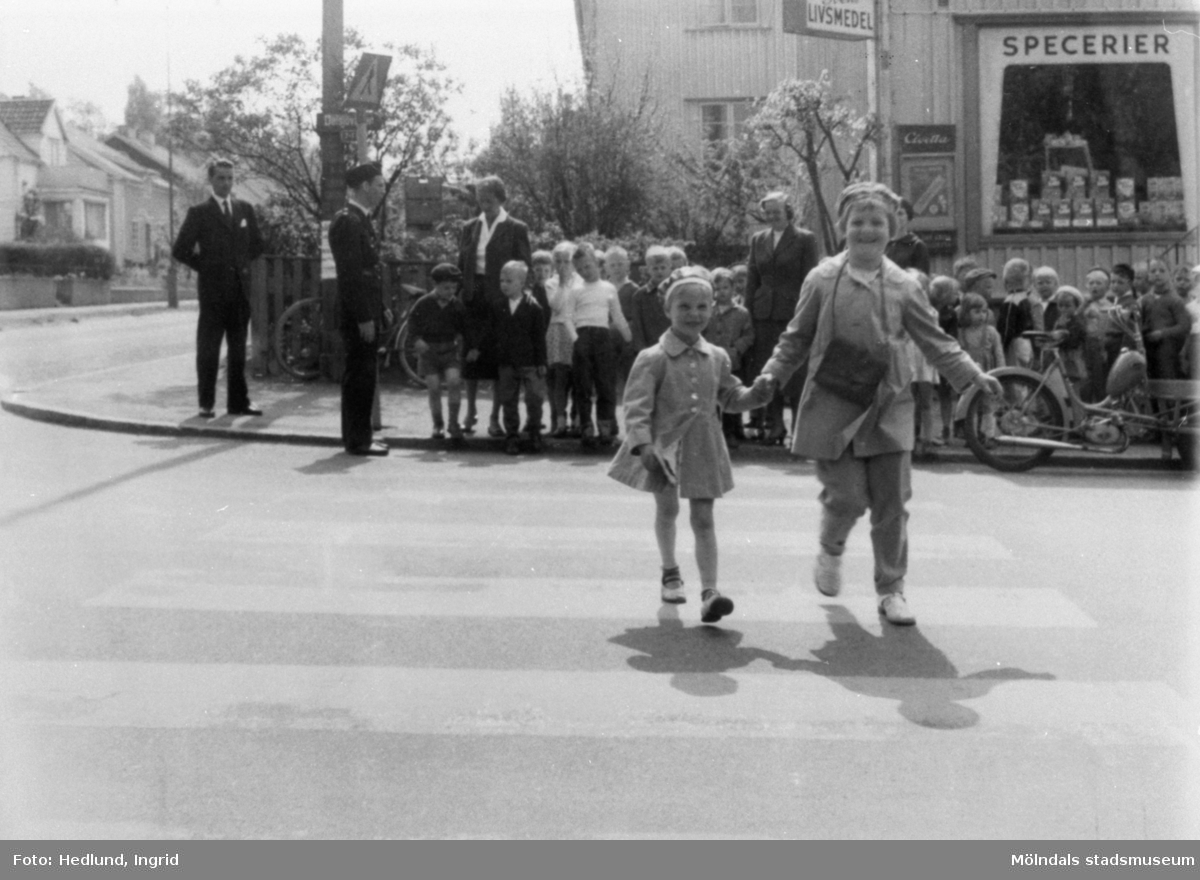 Barn som går över gatan på ett övergångsställe.