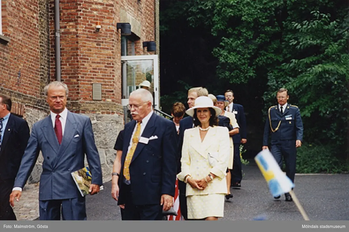 Besök av Kung Carl XVI Gustaf och Drottning Silvia på Mölndals Museum 1997-08-27 i samband med att Tjenstefolksbyggningen på Gunnebo slott invigdes. Mellan kungaparet ses kommunalrådet Bengt Odlöw. Bakom drottningens hatt ses kulturchefen Karl-Gunnar Nordanstad.