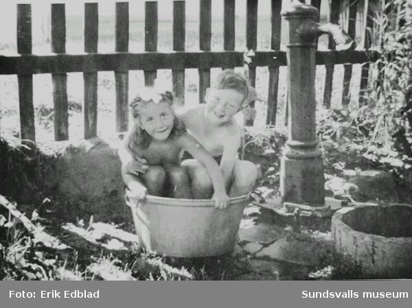 Bernt Edblad (f. 1938) och grannflickan Marianne badar i balja i familjen Siri och Erik Edblads trädgård, Södermalmsgatan 8, 1947. Familjen bodde här 1939 - 1960. Fastigheten ägdes av Helfrid Renström, som bodde i husets undervåning.